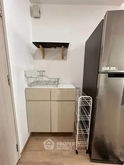 Modern kitchen corner with sleek fridge and storage solutions
