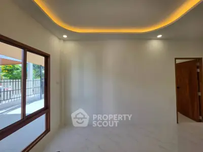 Modern interior with elegant ceiling lighting and large window overlooking outdoor space.