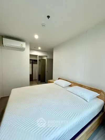 Spacious bedroom with modern design and ample natural light, featuring a comfortable bed and built-in wardrobe.