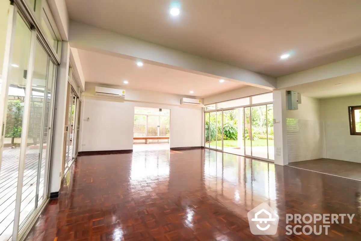 Spacious living room with polished hardwood floors, ample natural light, and a seamless flow to the outdoor area, perfect for entertaining and relaxation.