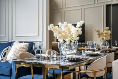 Luxurious dining area with elegant table setting and plush seating in a modern living space.