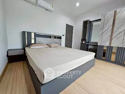 Modern bedroom with sleek furniture and minimalist design, featuring a comfortable bed and stylish wardrobe.