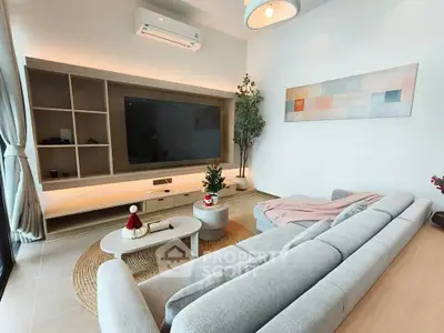 Modern living room with stylish decor, large TV, and cozy seating area, perfect for relaxation and entertainment.
