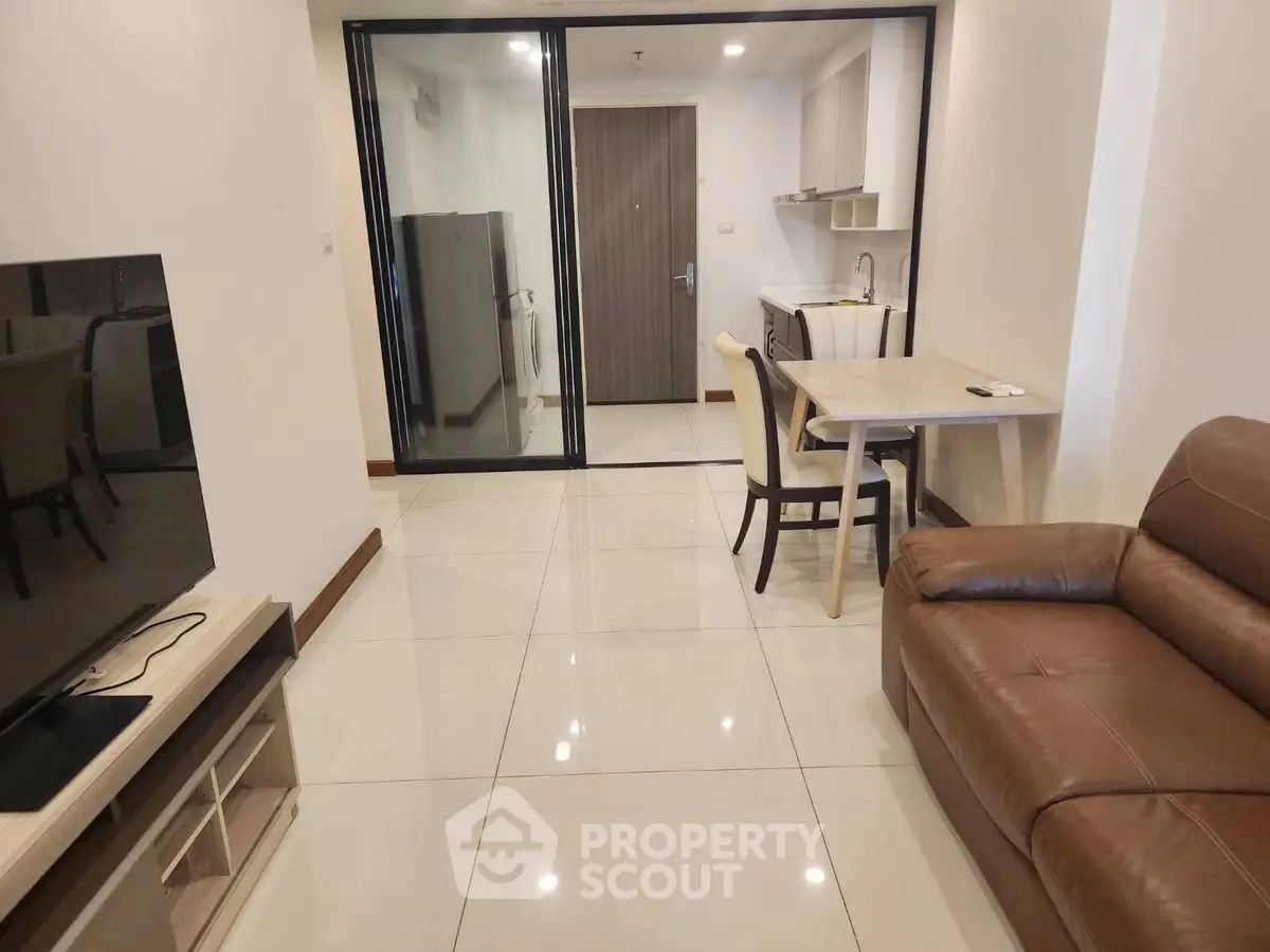 Modern living room with sleek furniture and open kitchen layout in a stylish apartment.