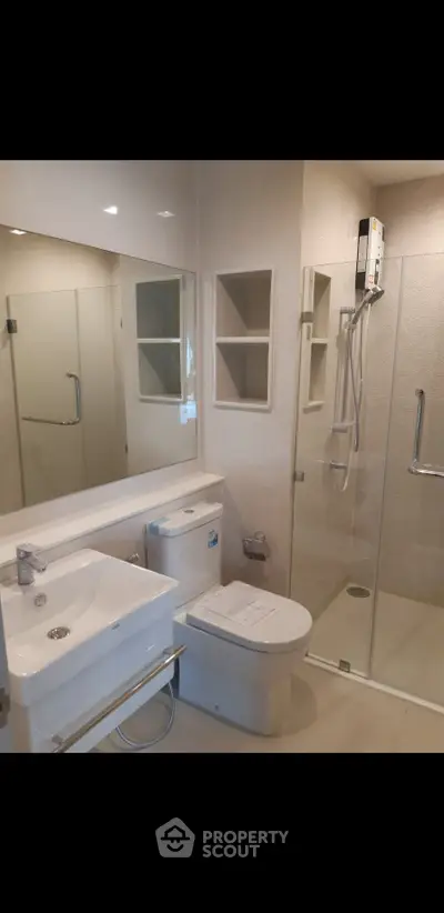 Modern bathroom with glass shower and sleek fixtures in a contemporary apartment.