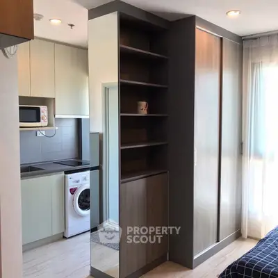 Modern apartment interior with compact kitchen and washing machine