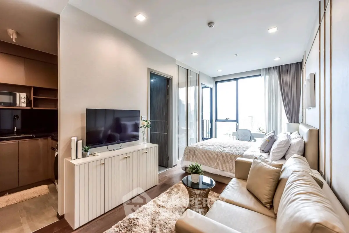 Modern studio apartment with open layout, featuring cozy living area, sleek kitchen, and bright bedroom with large windows.