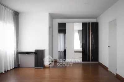 Spacious modern bedroom with sleek wardrobe and large windows for natural light.