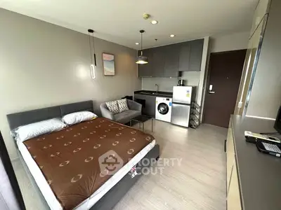 Modern studio apartment with integrated kitchen and laundry area, featuring sleek design and cozy living space.