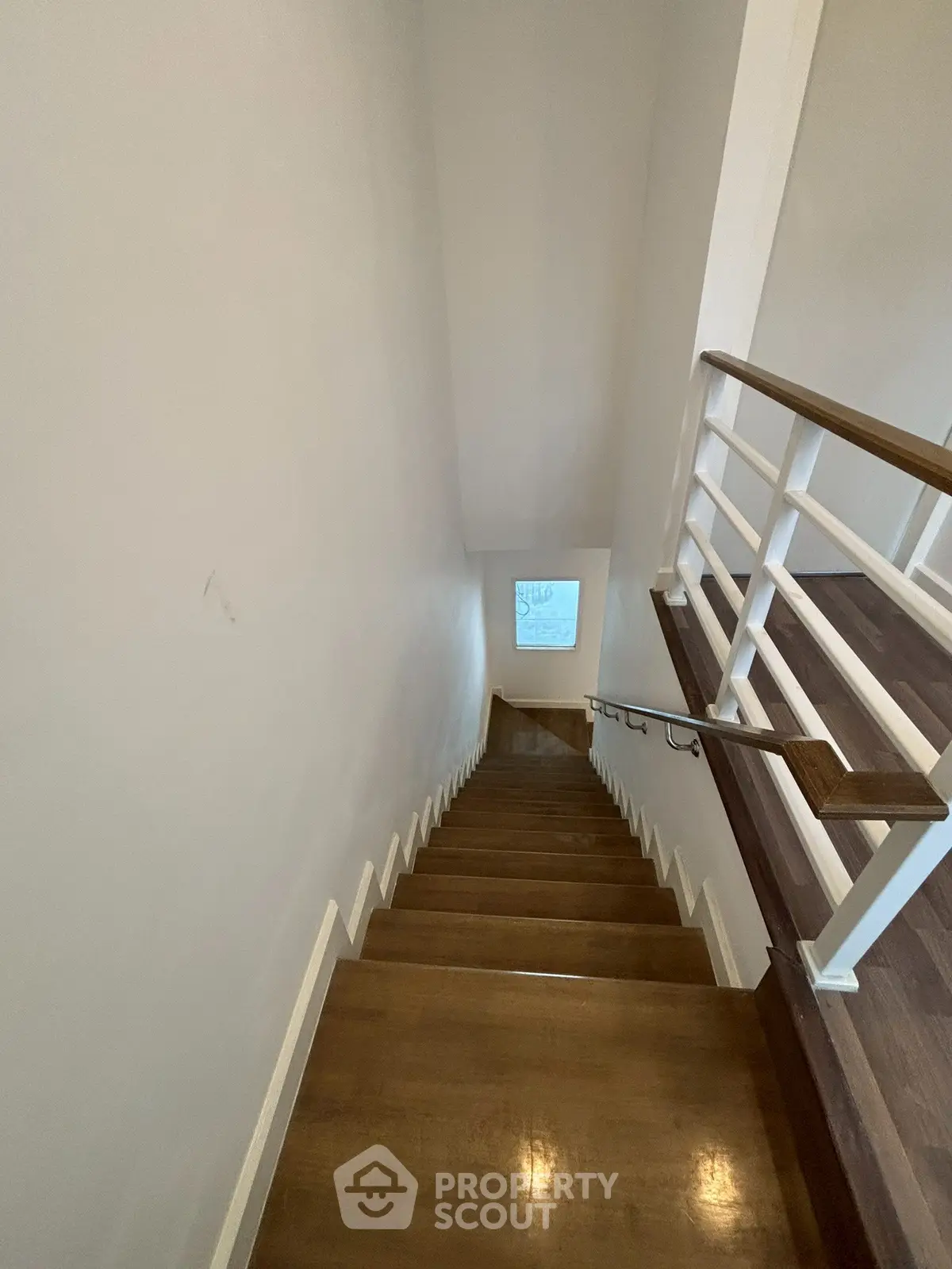 Modern staircase with wooden steps and sleek railing in a contemporary home
