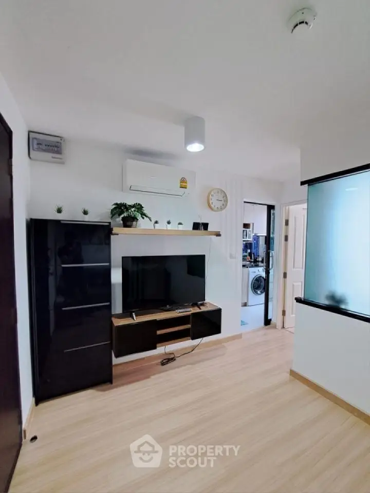 Modern living room with sleek TV setup and stylish decor in a cozy apartment.