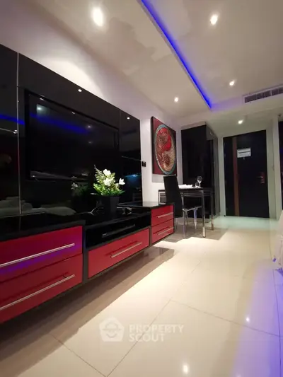 Modern living room with sleek black and red furniture, ambient lighting, and elegant decor.