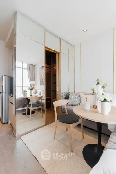 Modern living room with elegant decor and mirrored wardrobe in a stylish apartment.