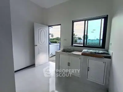 Bright kitchen with open layout and scenic view, featuring modern cabinetry and sleek design.