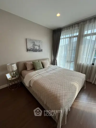 Cozy bedroom with large window and elegant decor, perfect for relaxation.