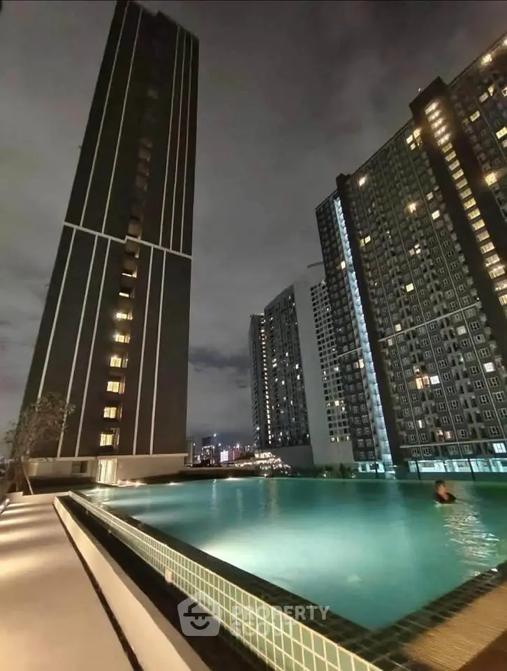 Stunning night view of modern high-rise buildings with illuminated infinity pool.