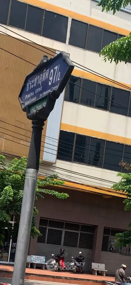 Street view of a commercial building with a street sign in front, ideal for business opportunities.