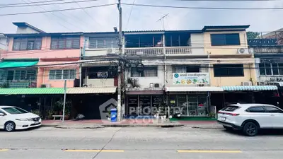 Charming mixed-use building with retail shops and residential units in a bustling urban area.