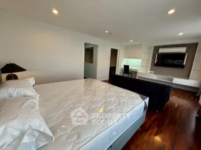 Spacious bedroom with modern decor and hardwood floors