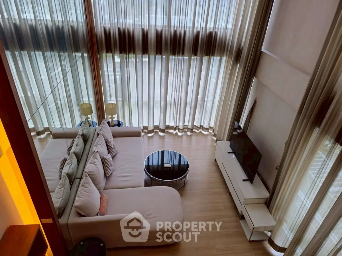 Luxurious high-ceiling living room with elegant curtains and modern furniture