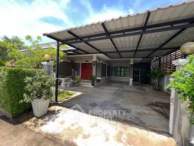 Charming single-story home with spacious carport and lush greenery, perfect for family living.