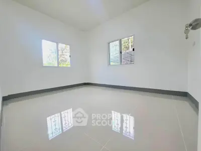 Spacious empty room with glossy tiled floor and large windows