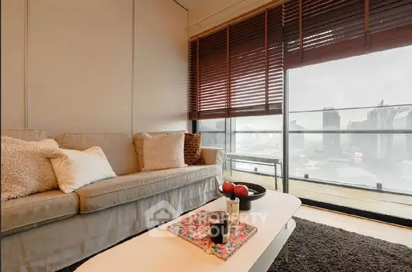 Modern living room with cozy sofa and city view from large balcony.