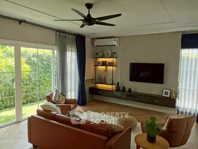 Spacious living room with modern decor, large windows, and garden view, perfect for relaxation and entertainment.