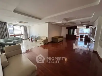 Spacious open-plan living room with hardwood floors and ample natural light, perfect for modern living.
