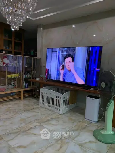 Spacious living room with large TV and elegant flooring