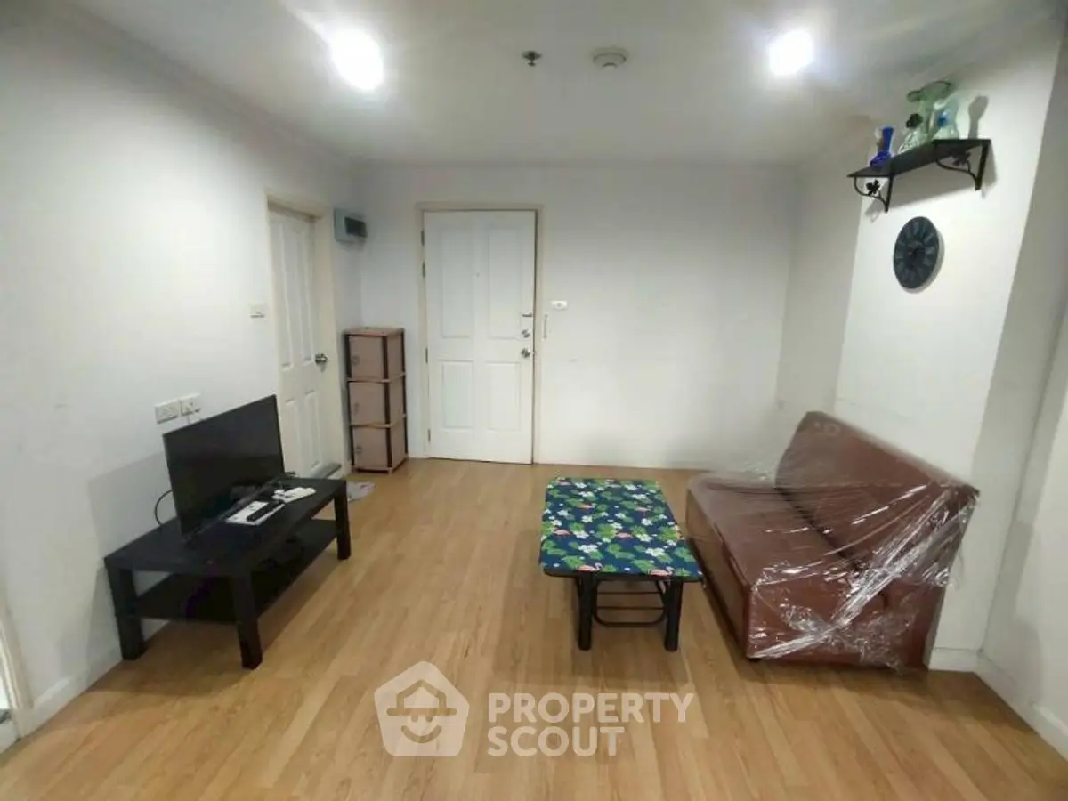 Spacious living room with modern decor and wooden flooring in a cozy apartment.