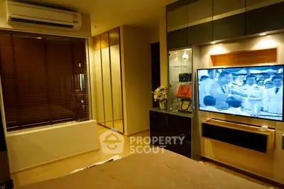 Modern bedroom with sleek design, featuring a wall-mounted TV and stylish decor.