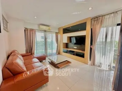 Spacious living room with modern leather sofa and entertainment center
