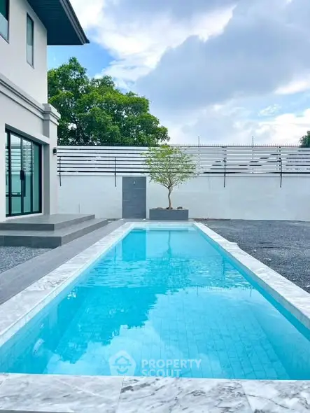 Luxurious modern home with sleek swimming pool and spacious outdoor area.