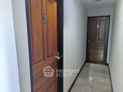 Apartment hallway with wooden doors and tiled floor