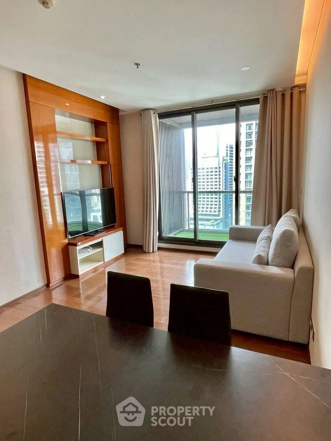 Modern living room with city view, stylish furniture, and large windows for natural light.