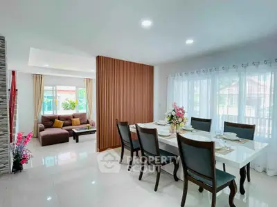 Spacious open-plan living and dining area with elegant decor and abundant natural light.