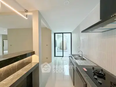 Modern kitchen with sleek design and open layout, featuring gas stove and spacious countertops.