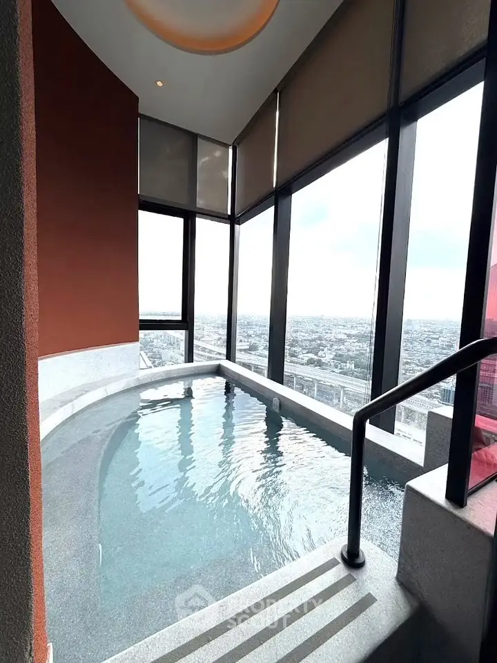 Luxurious indoor pool with panoramic city views in high-rise building