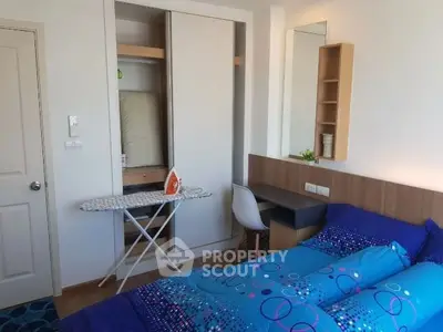 Cozy bedroom with modern decor, featuring a built-in wardrobe and a compact workspace.