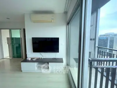 Modern living room with large windows and balcony view in urban apartment.