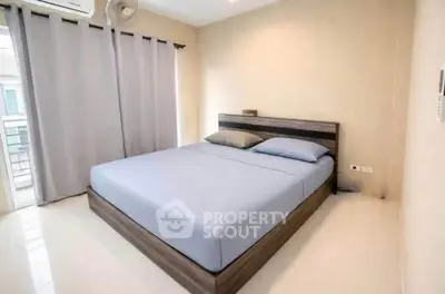 Modern bedroom with minimalist design and large window for natural light.