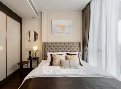 Luxurious bedroom with elegant decor and large window offering natural light
