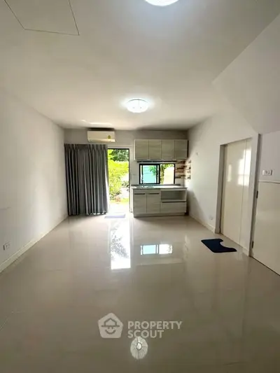 Spacious open-plan living area with modern kitchen and large windows for natural light.
