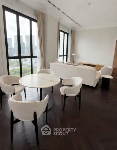 Luxurious living room with city view, elegant furniture, and large windows in a high-rise apartment.