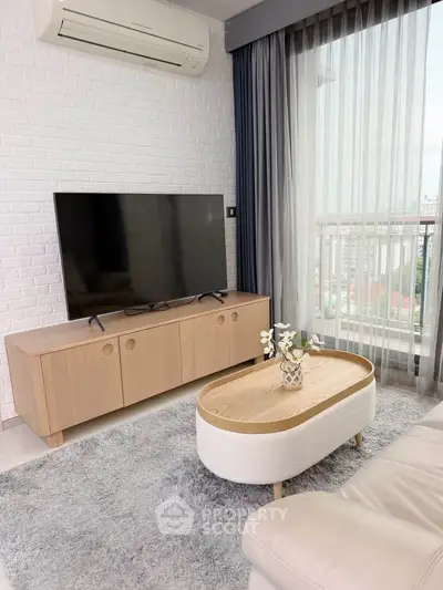 Modern living room with stylish furniture and large TV, featuring a cozy atmosphere and natural light.