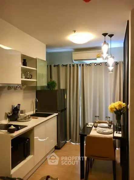 Modern kitchen with dining area, featuring sleek cabinetry and stylish lighting, perfect for urban living.