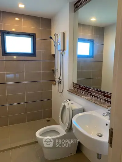 Modern bathroom with sleek tiles and contemporary fixtures in a stylish real estate property.