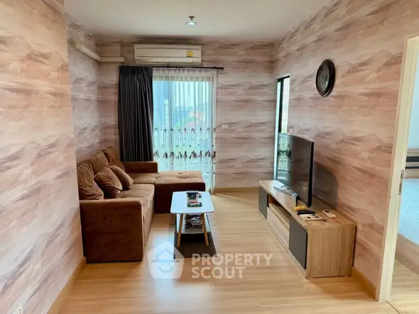 Cozy living room with modern decor and natural light, featuring a comfortable sofa and entertainment center.