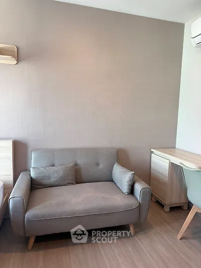 Cozy living room with modern gray sofa and wooden furniture, perfect for relaxation.
